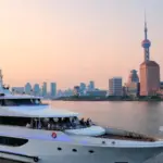 A luxurious cruise ship sailing through Canadian waters with a backdrop of stunning mountains.