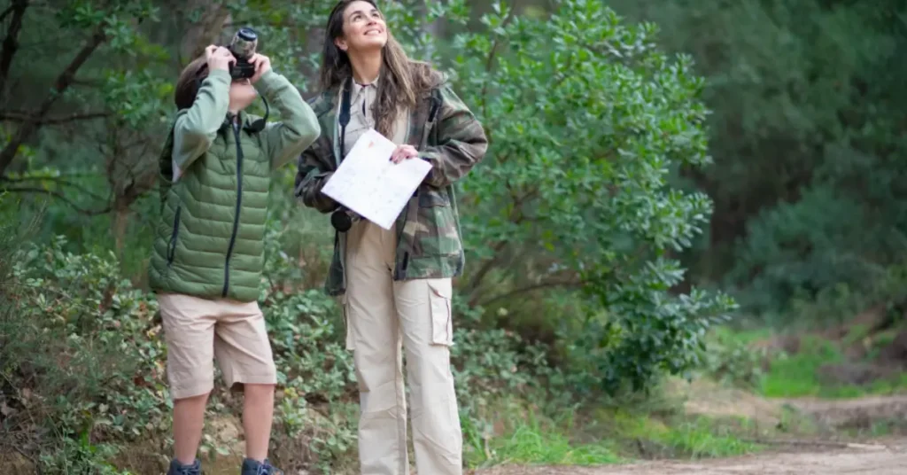 Bird watching enthusiasts in a natural Canadian habitat with binoculars and field guide