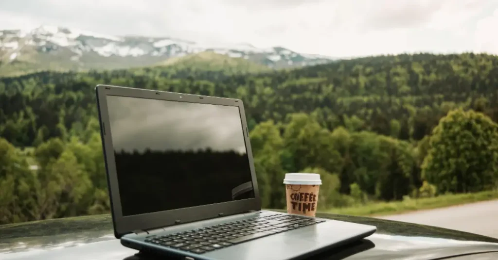 Used laptop on wooden table with visible wear