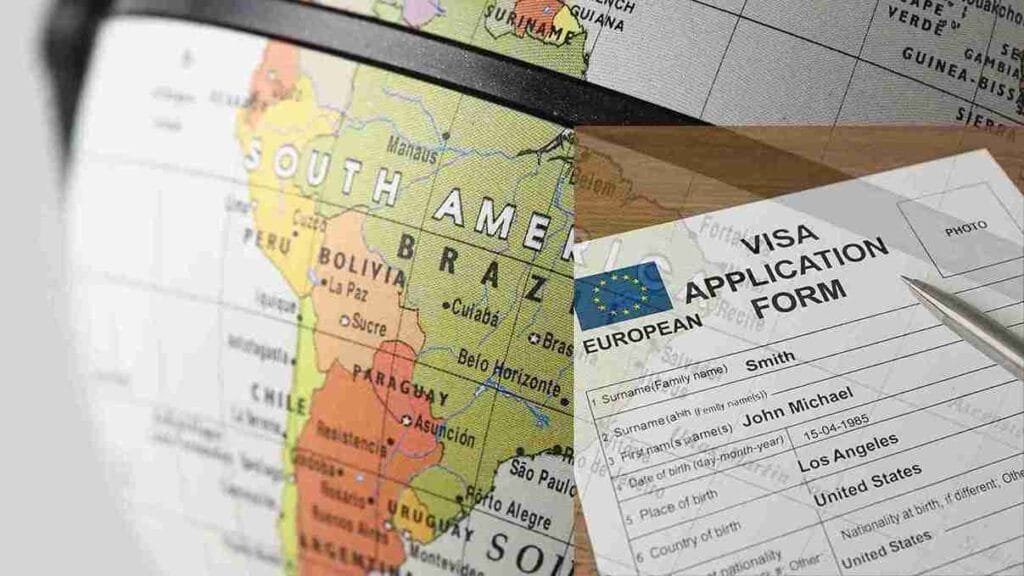 European visa application form partially filled out with a silver pen on a wooden table.